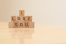 " I love you" spelled out in stacked scrabble tiles
