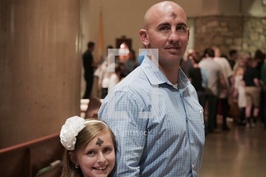 a father and daughter at mass for Ash Wednesday services 