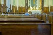 elderly man praying alone in church 