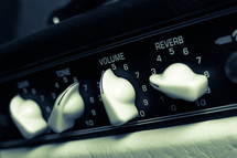 Guitar amplifier level dials: tone, gain, volume & reverb in duo-tone.
