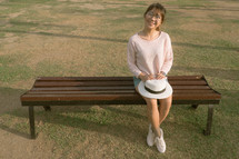 a young woman sitting on a park bench 