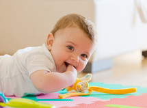 toddler plays on the colored rubber mat