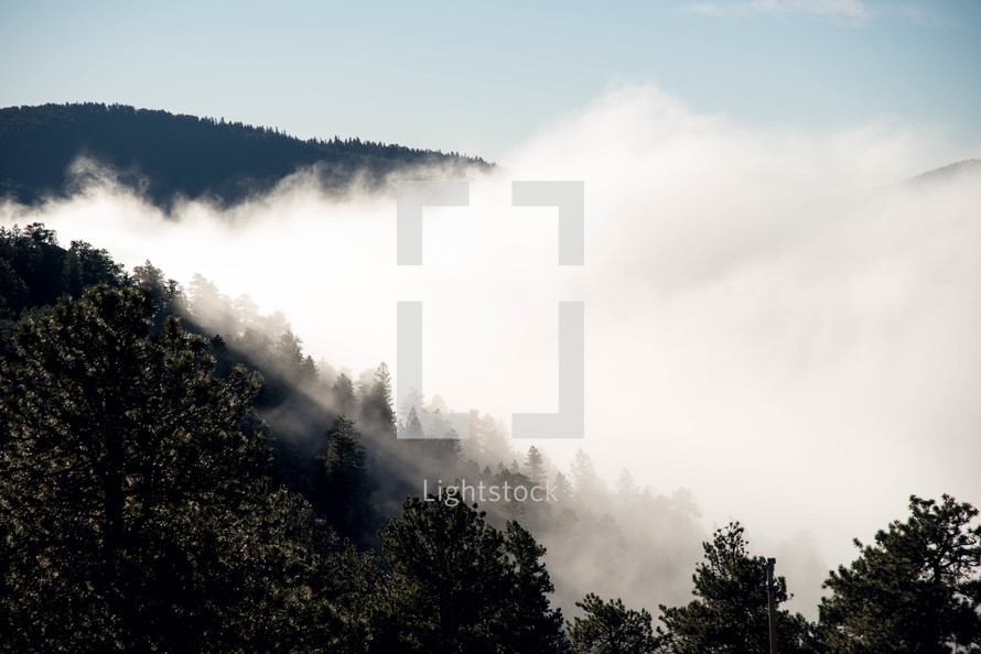 rising clouds and fog in a valley 