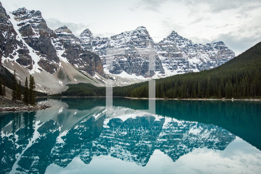 reflection of snowy mountains on lake water 
