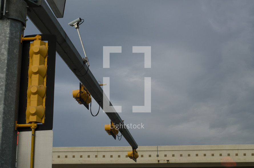 Stoplight pole against cloudy sky