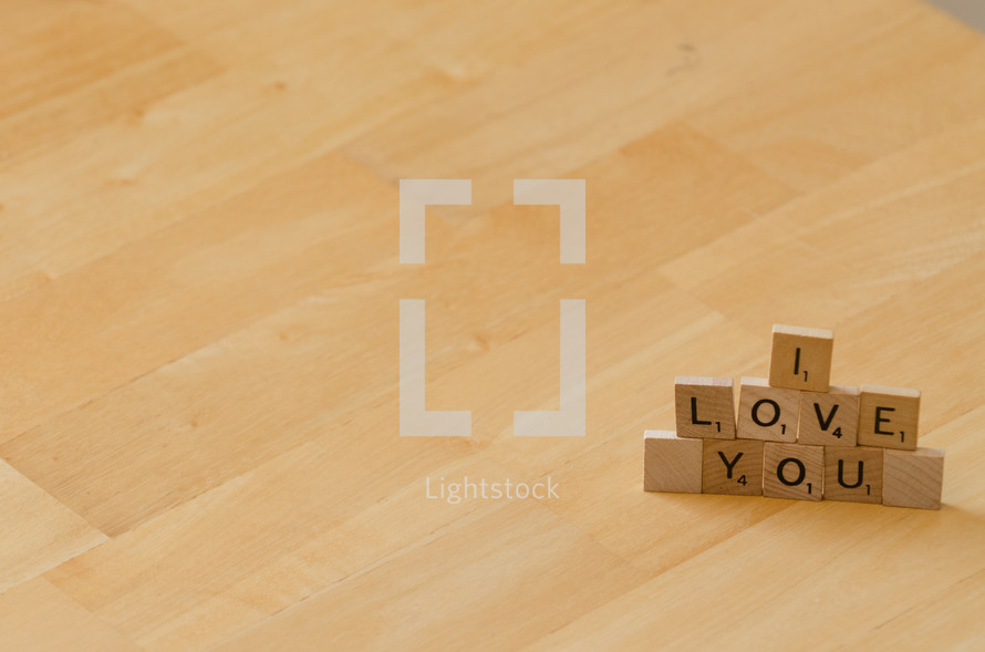 "I love you" spelled out in stacked scrabble letters.