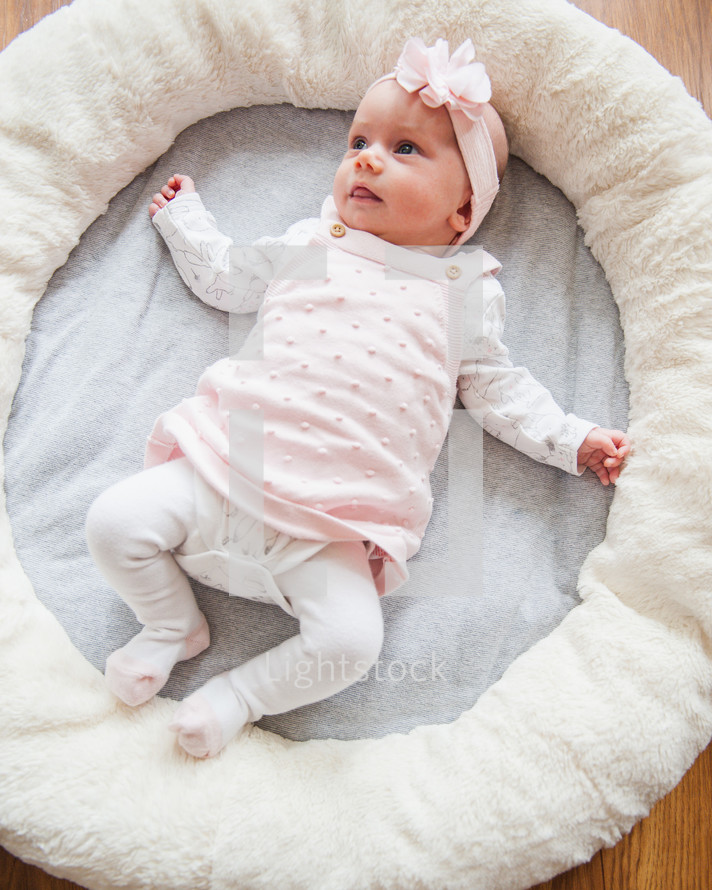 awake infant girl on a mat 