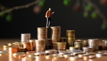 Miniature people - Businessman standing on coin stack, Money saving concept
