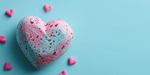 Speckled heart surrounded by smaller hearts on a teal background. Valentines day concept