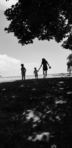 silhouettes of a mother and children on a beach 