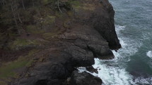 Aerial view of rough waters against the cliffs in the pacific northwest