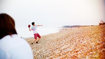 man throwing a football on the beach 