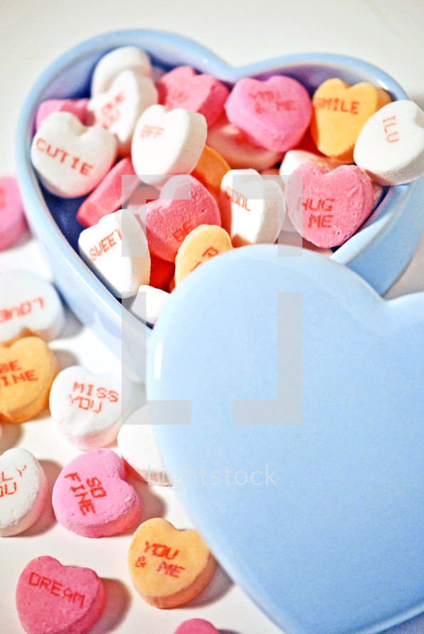 Candy hearts in a heart-shaped bowl.