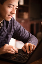 man typing on a laptop computer 