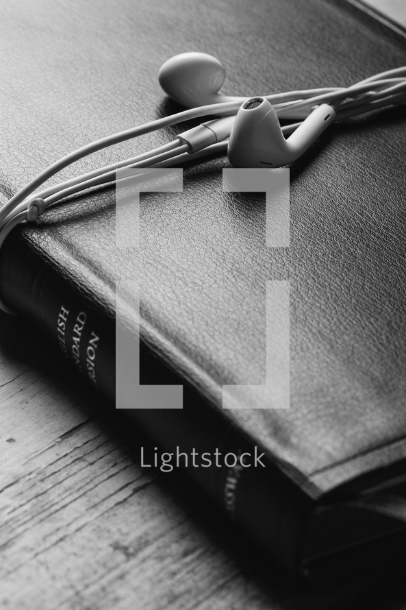ear buds wrapped around a Bible