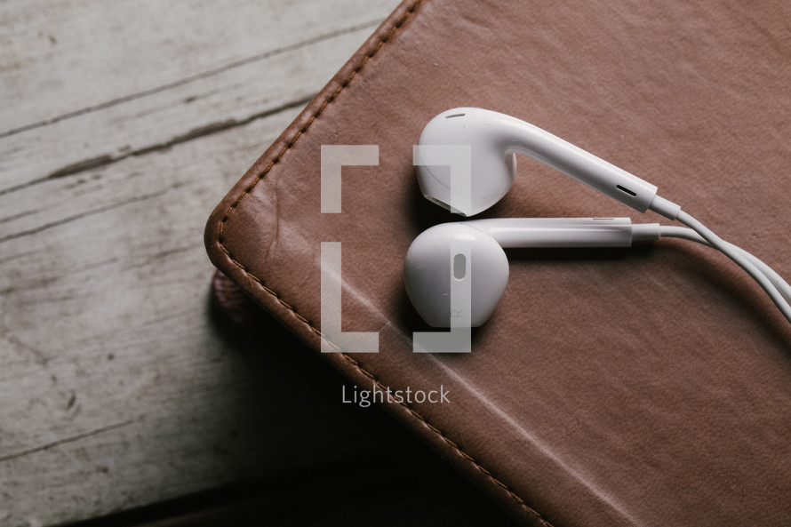 ear buds resting on a Bible