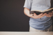 Man's hands holding an open Bible.