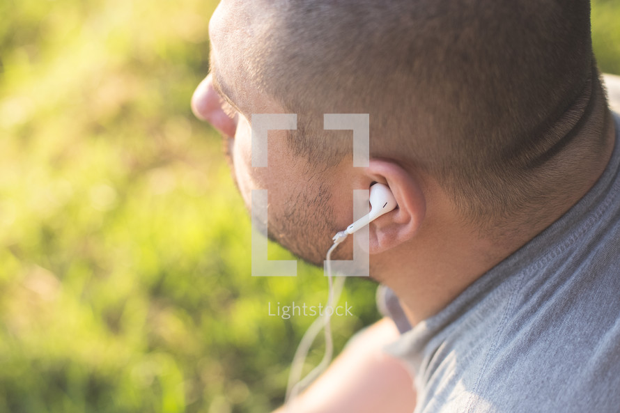 A man listening to music through earphones.