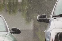 downpour of rain bounces off vehicles