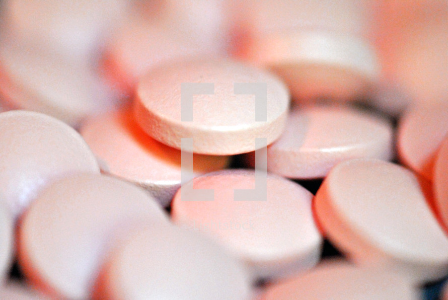 Closeup of pink medicine tablets.