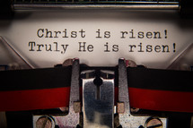 "Christ is risen" typed on a page in a typewriter.