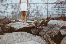 a woman standing on rocks bare foot 