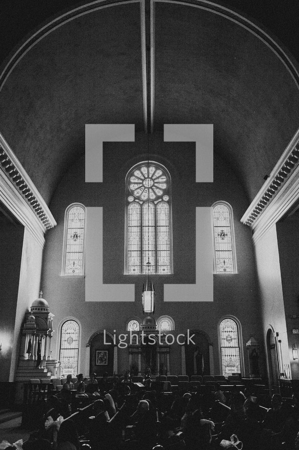A congregation sitting in pews inside a church. 