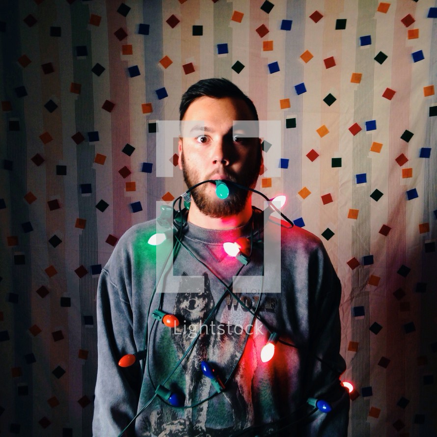 man wrapped in Christmas lights 