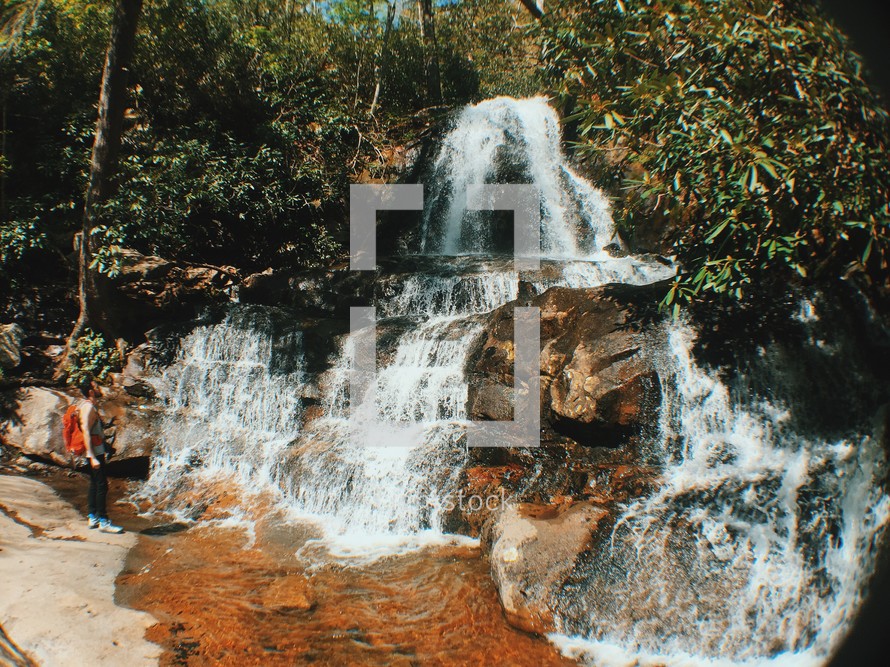 woman looking at a rushing waterfall 