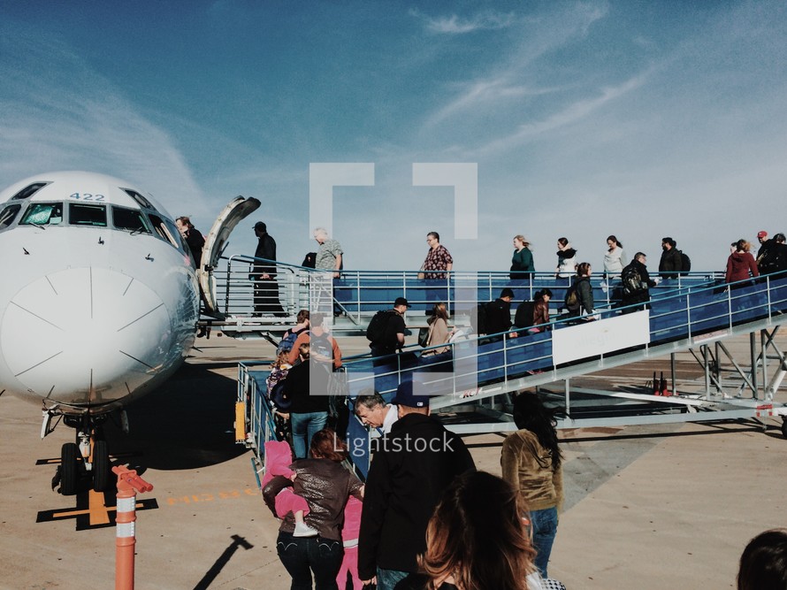 people boarding a small plane 