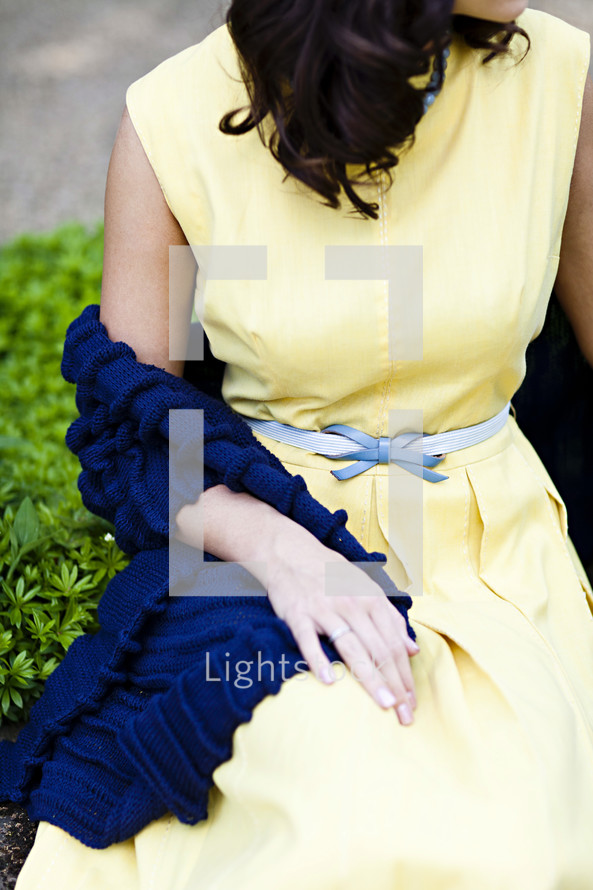 A young woman sitting yellow dress summer spring blue shawl 