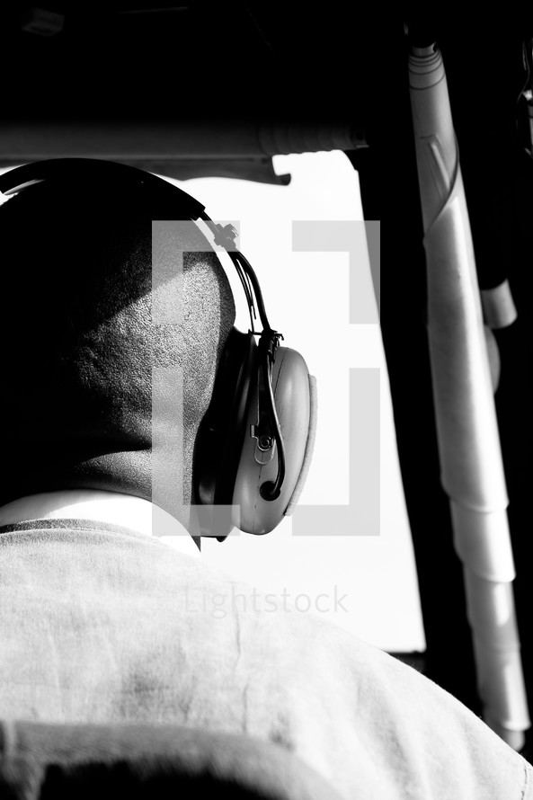 man in headphones looking out a window