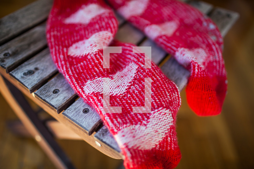 Red socks with heart pattern on wooden chair