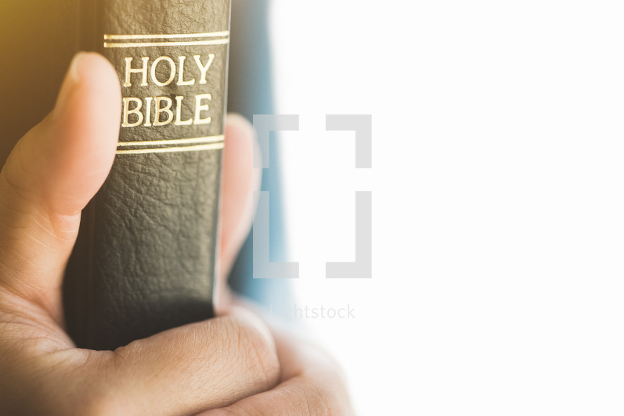 hands grasping a Bible 