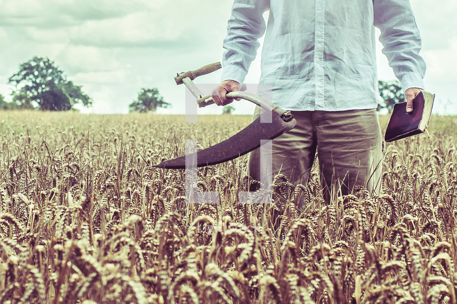 a man with a Scythe blade and a Bible in a wheat field 