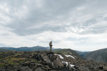 man standing on top of a rocky mountaintop 