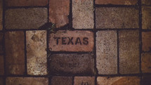 word Texas stamped in brick 