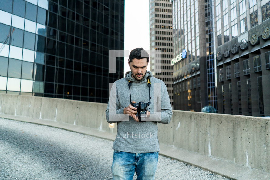 a man standing in a city holding a camera 
