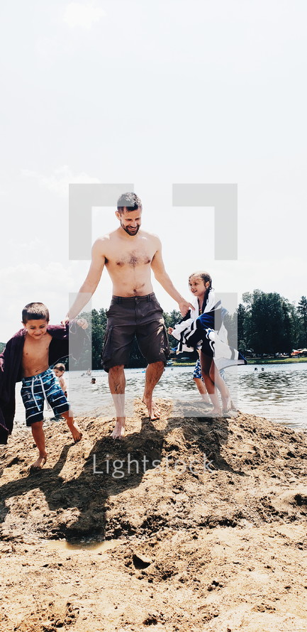 father and kids on a beach 