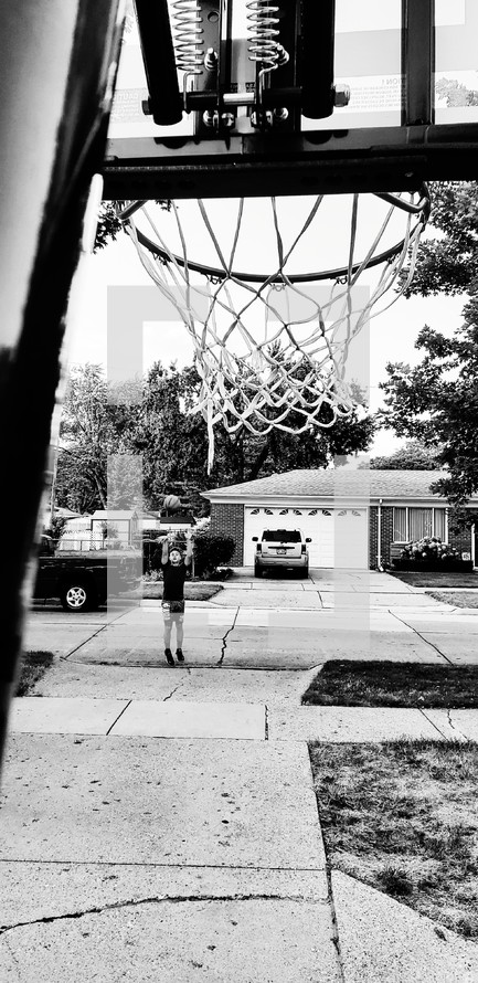 boy playing basketball in his driveway 
