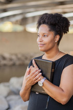 a woman holding a Bible close to her heart