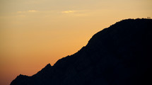A silhouette of a mountain peak. 