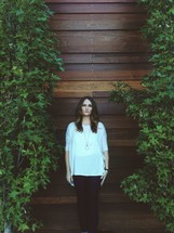 woman standing in front of a wood wall 