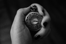 woman's hand holding a pocket watch 