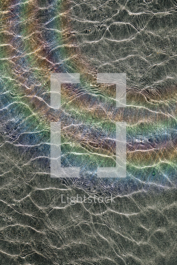 rainbow reflected on the water ripples, abstract background