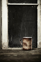 A coffee mug sits next to a window sill