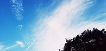 plane contrails against a blue sky 