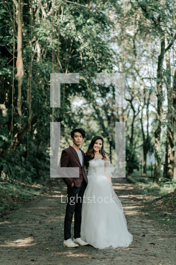 portrait of a bride and groom standing a jungle 