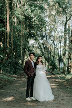 portrait of a bride and groom standing a jungle 