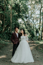 portrait of a bride and groom standing in a jungle 